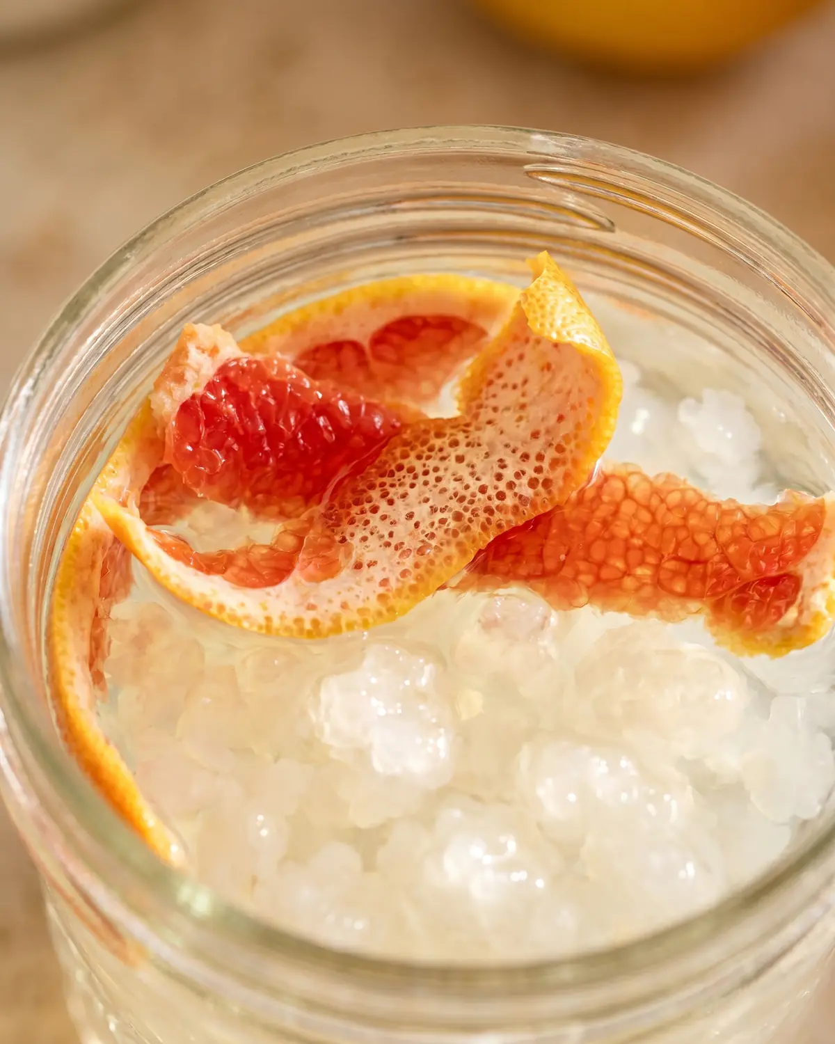 water kefir drink Detail van pompelmoesschil op waterkefir met wazige doorschijnende korrels onder het oppervlak.
